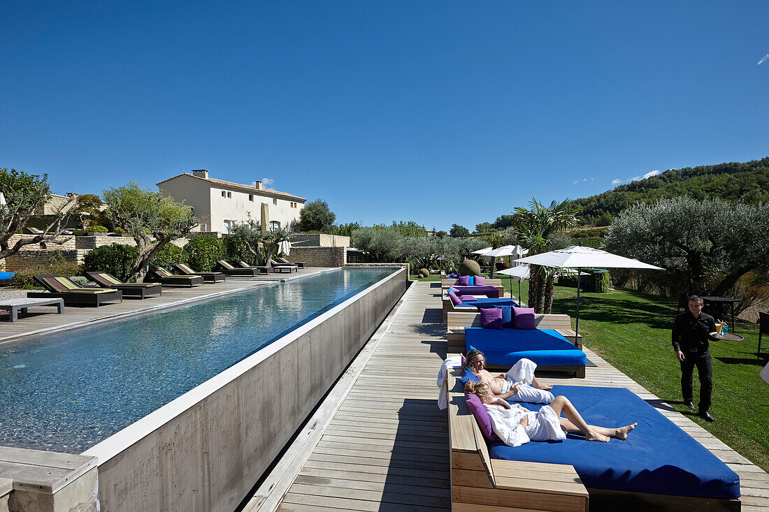 Guests relaxing on sun loungers at a hotel pool, Saint-Saturnin-les-Apt, Provence, France