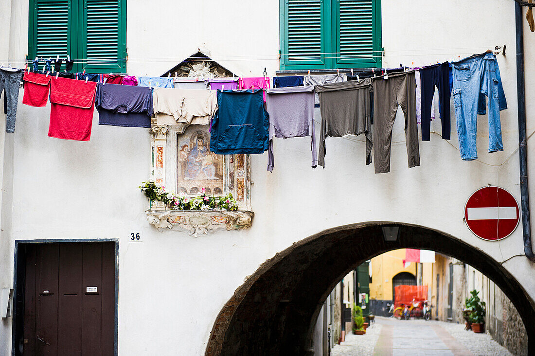 Washing hanging above an alley, Albenga, Province of Savona, Riviera di Ponente, Liguria, Italy
