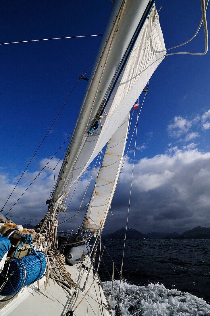 Boat in full sail passing Brecknock Passage, Tierra del Fuego, Chile