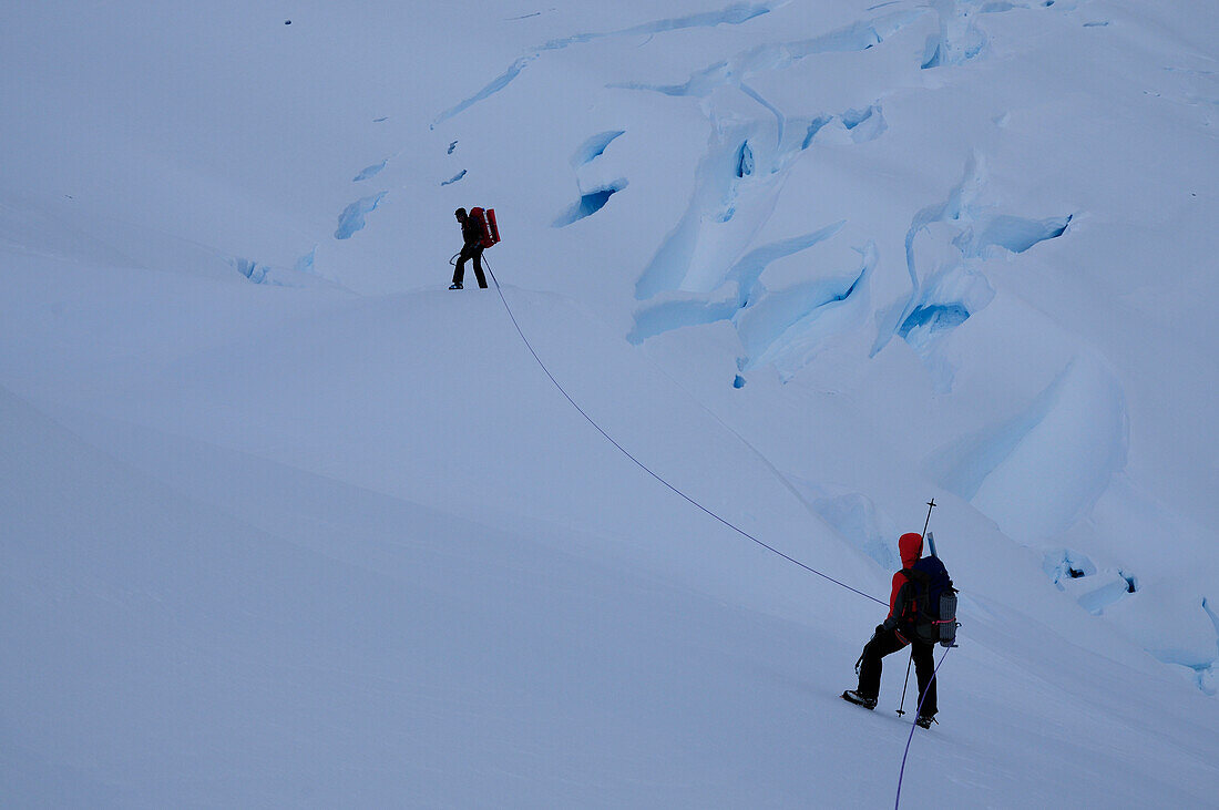Two mountaineers passing a glacier, Monte Sarmiento, Cordillera Darwin, Tierra del Fuego, Chile