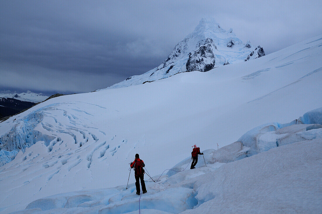 Zwei Bergsteiger auf einem Gletscher unterhalb des Monte Sarmiento, Cordillera Darwin, Feuerland, Chile