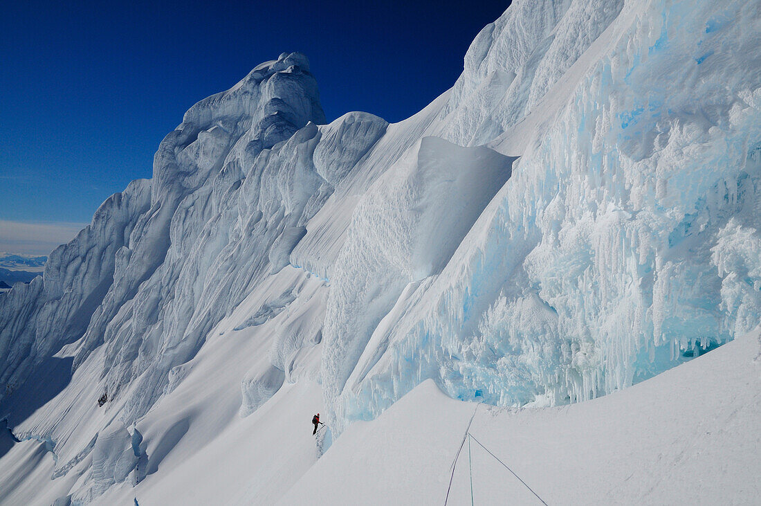 Mountaineer in a bergschrund of the north face of Monte Sarmiento, Cordillera Darwin, Tierra del Fuego, Chile