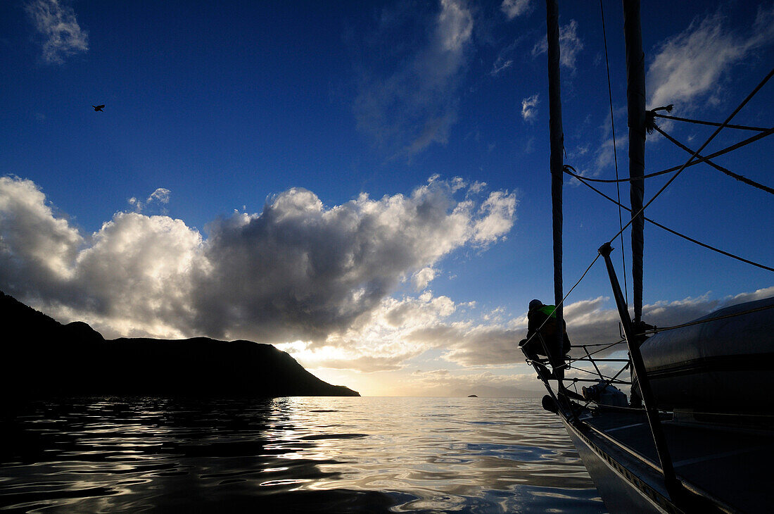 Man on a bow of a sailing boat, Cape Froward in background, Strait of Magellan, Chile