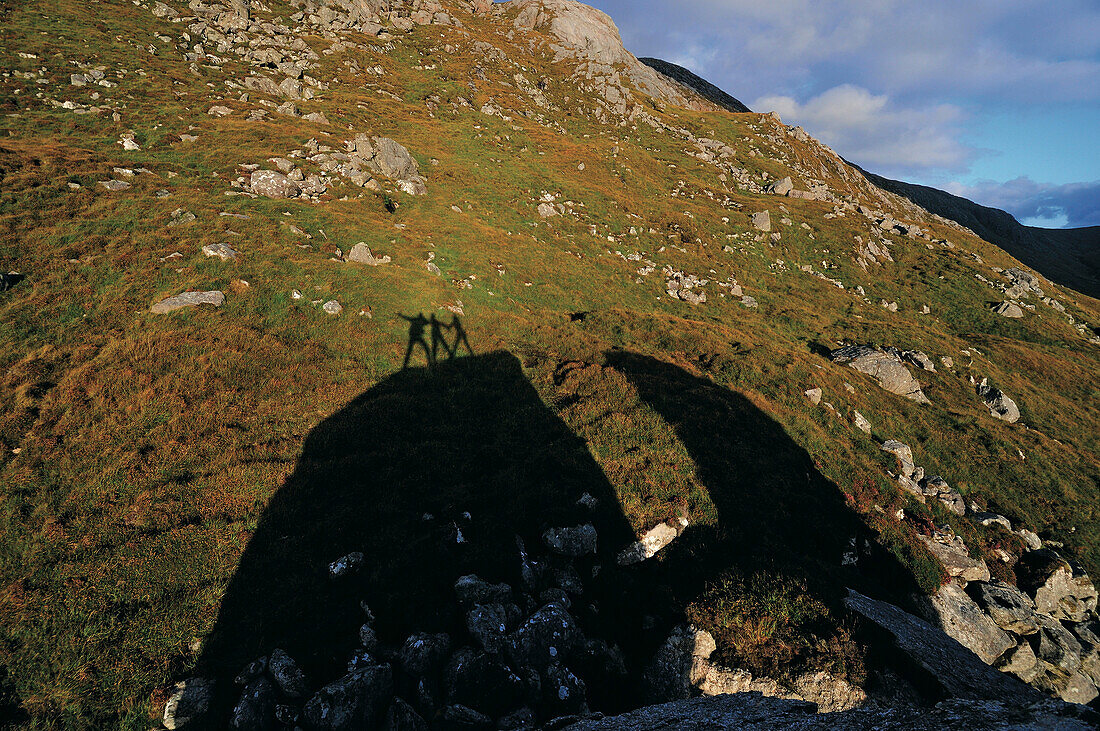 Schattenbild von drei Personen auf einem Felsen am Loch Crabhadail, Harris, Lewis and Harris, Schottland, Großbritannien