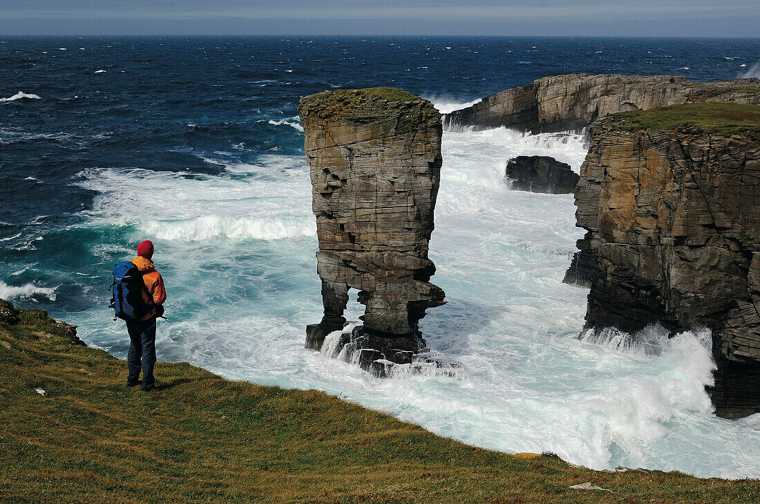 Hiker looking at Castle of Yesnaby, Mainland, Orkney Islands, Scotland, Great Britain
