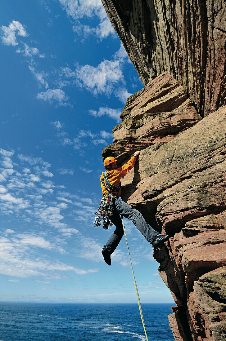 Climber ascending Old Man of Hoy, Hoy, Orkney Islands, Scotland, Great Britain