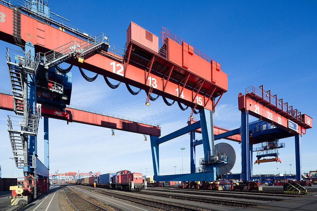 Freight train under a container bridge, Hamburg, Germany