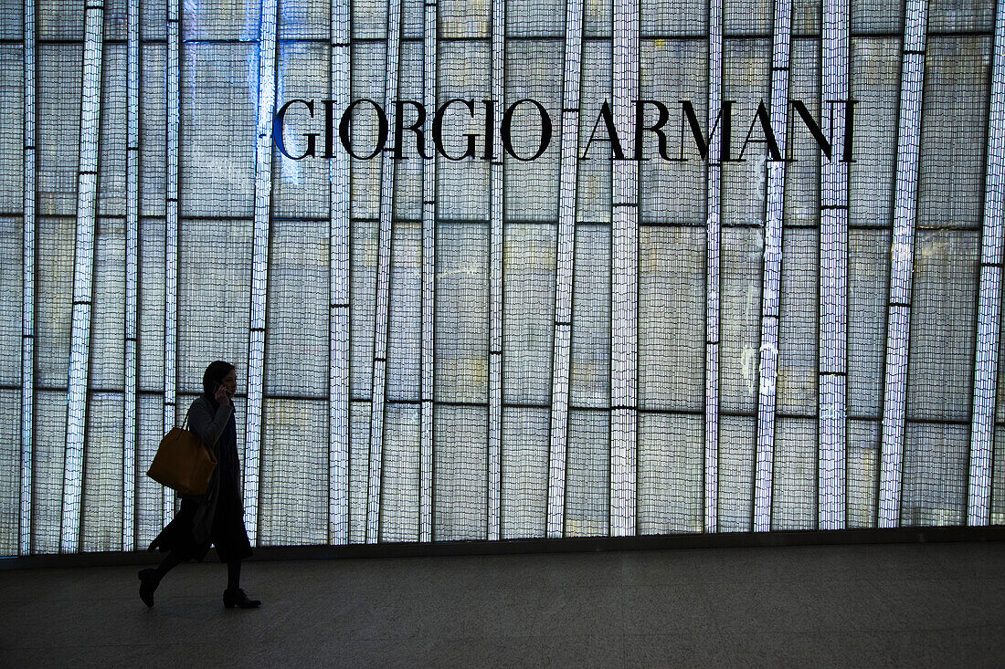 Silhouette einer Frau vor Ladenfassade von Giorgio Armani Geschäft, Central, Hong Kong Island, Hongkong, China