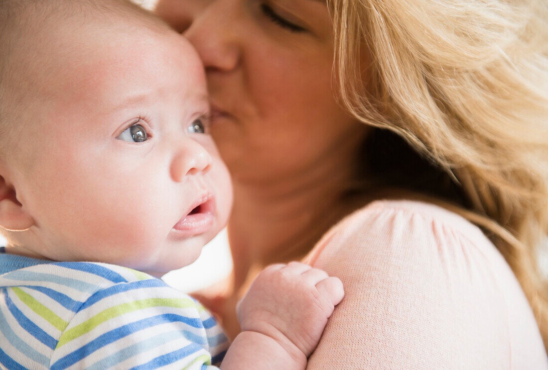 Caucasian mother kissing baby, Jersey City, New Jersey, USA