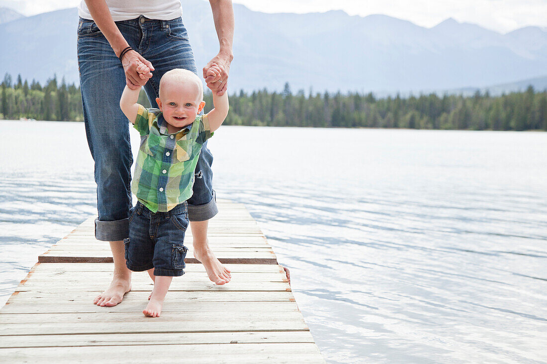 Caucasian mother and baby on dock over lake, Jasper, Alberta, Canada