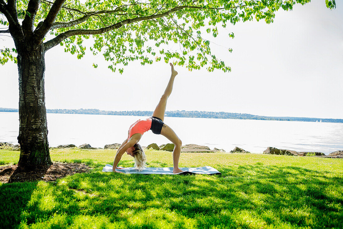 Caucasian woman practicing yoga outdoors, Seattle, WA, USA