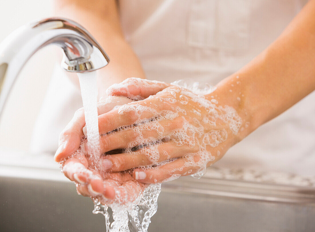 Caucasian woman washing her hands, Park City, Utah, USA