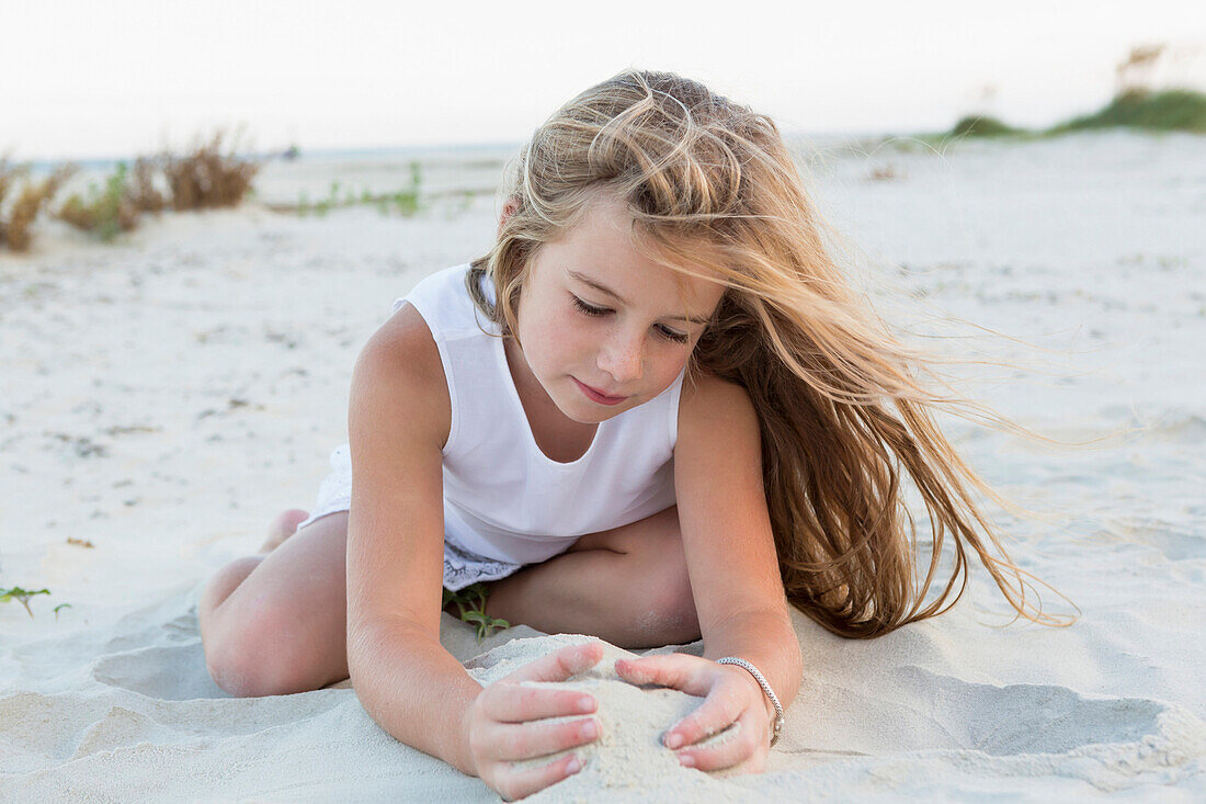 Girl playing in sand on beach, Brunswick, Georgia, United States