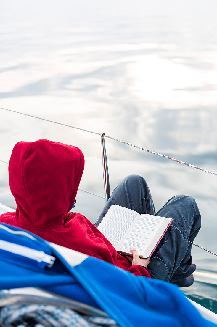 Frau liest an Deck von einem Segelboot, Golf von Triest, Görz, Friaul-Julisch Venetien, Italien