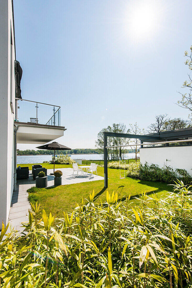 Terasse mit Blick auf Wasser in einer modernen Architekturvilla in Brandenburg, Deutschland