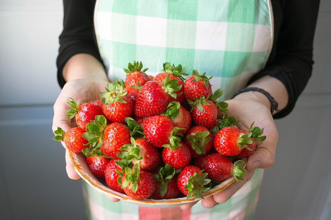 Housewife with a bowl of fresh strawberries