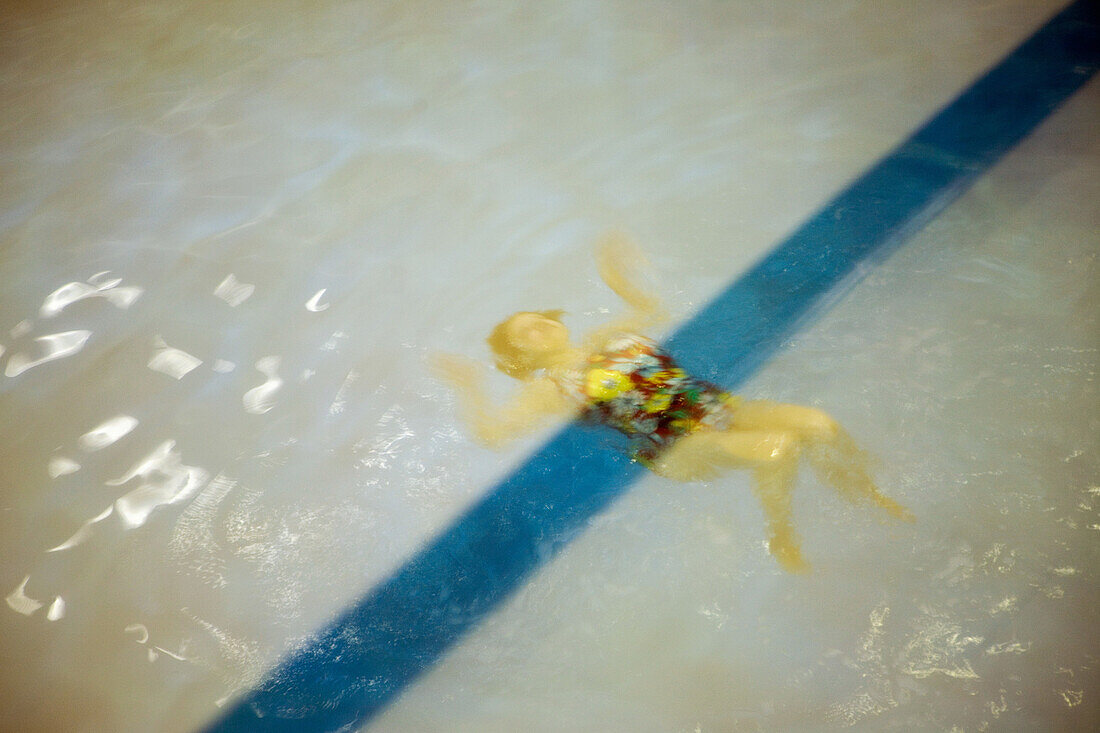 Woman swimming underwater in pool