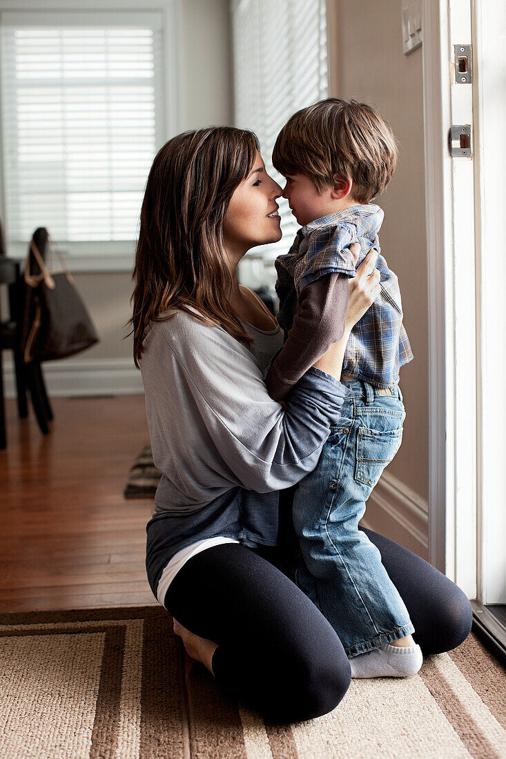 Mother and young son touching noses