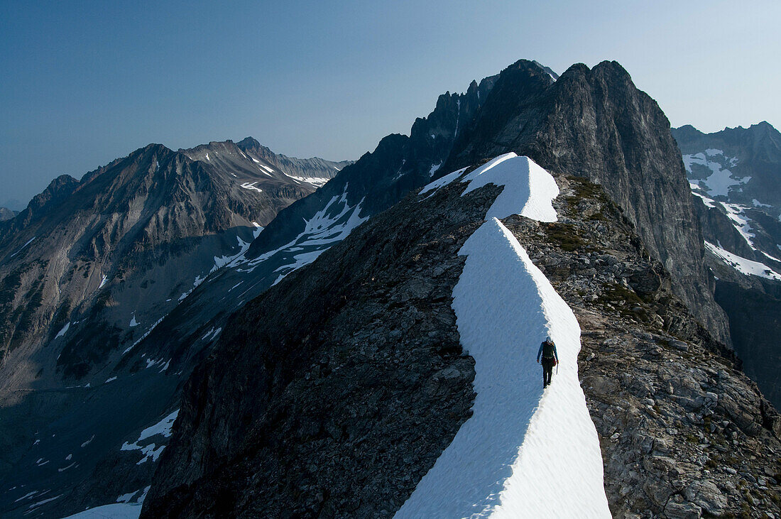 Female climber traversing snowy ridge, Redoubt Whatcom Traverse, North Cascades National Park, WA, USA