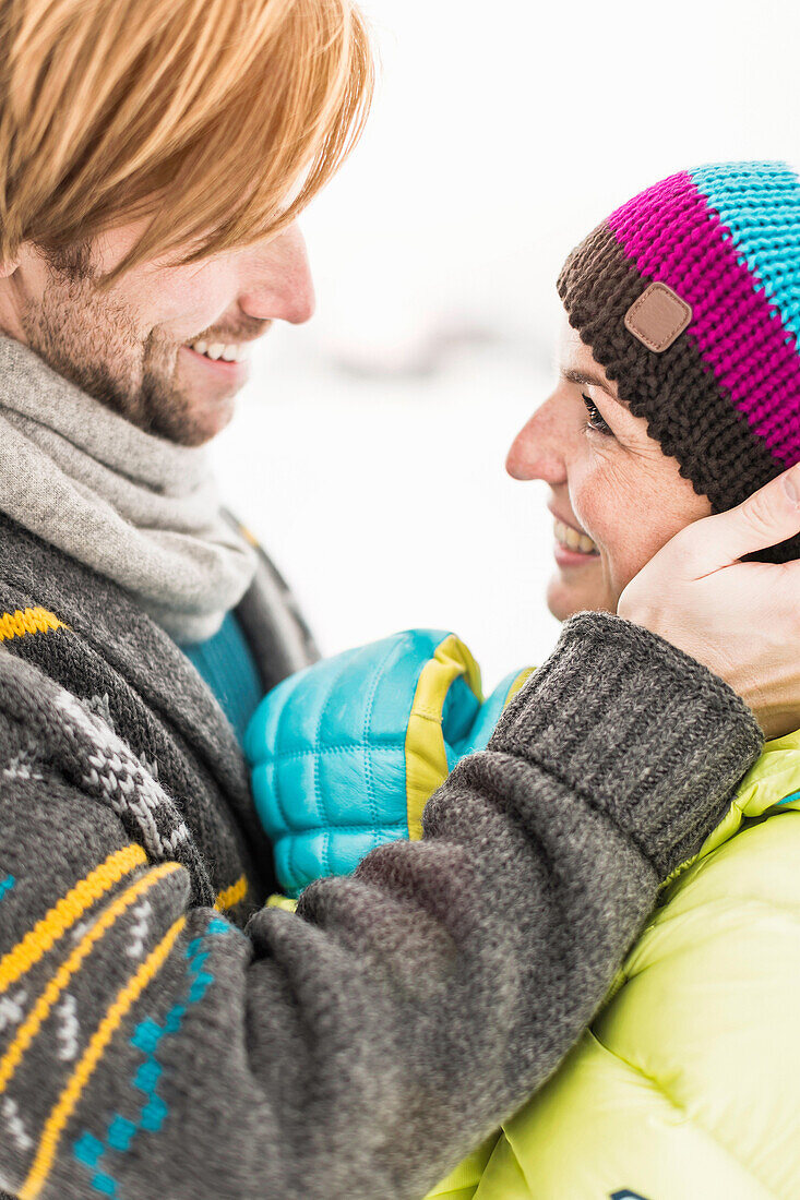 Man touching woman's face, woman wearing knit hat