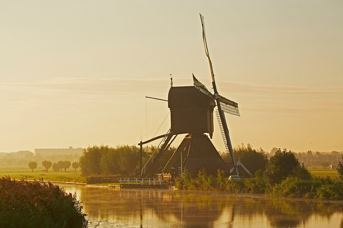 First morning sun at the old windmills at Kinderdijk, Province of Southern Netherlands, South Holland, Netherlands, Europe