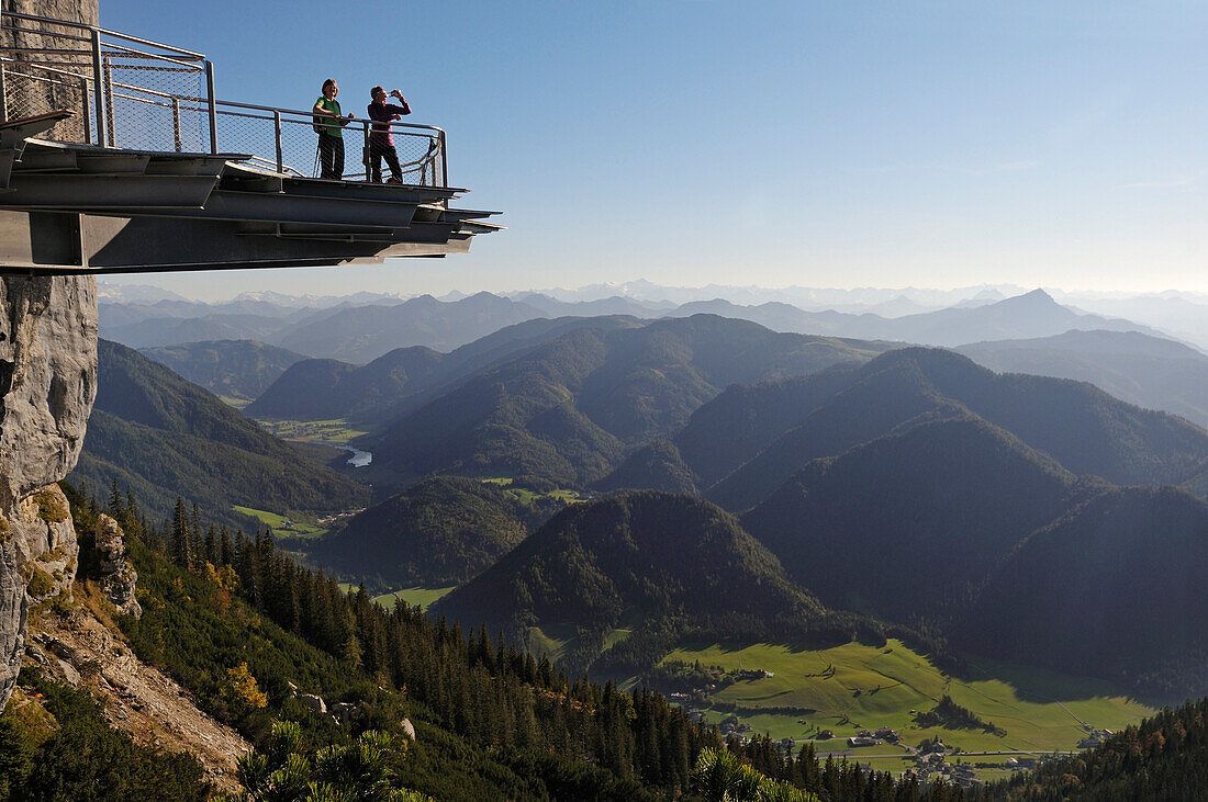 Female hikers enjoying view from observation platform at mount Steinplatte, Triassic Parc, Waidring, Tyrol, Austria