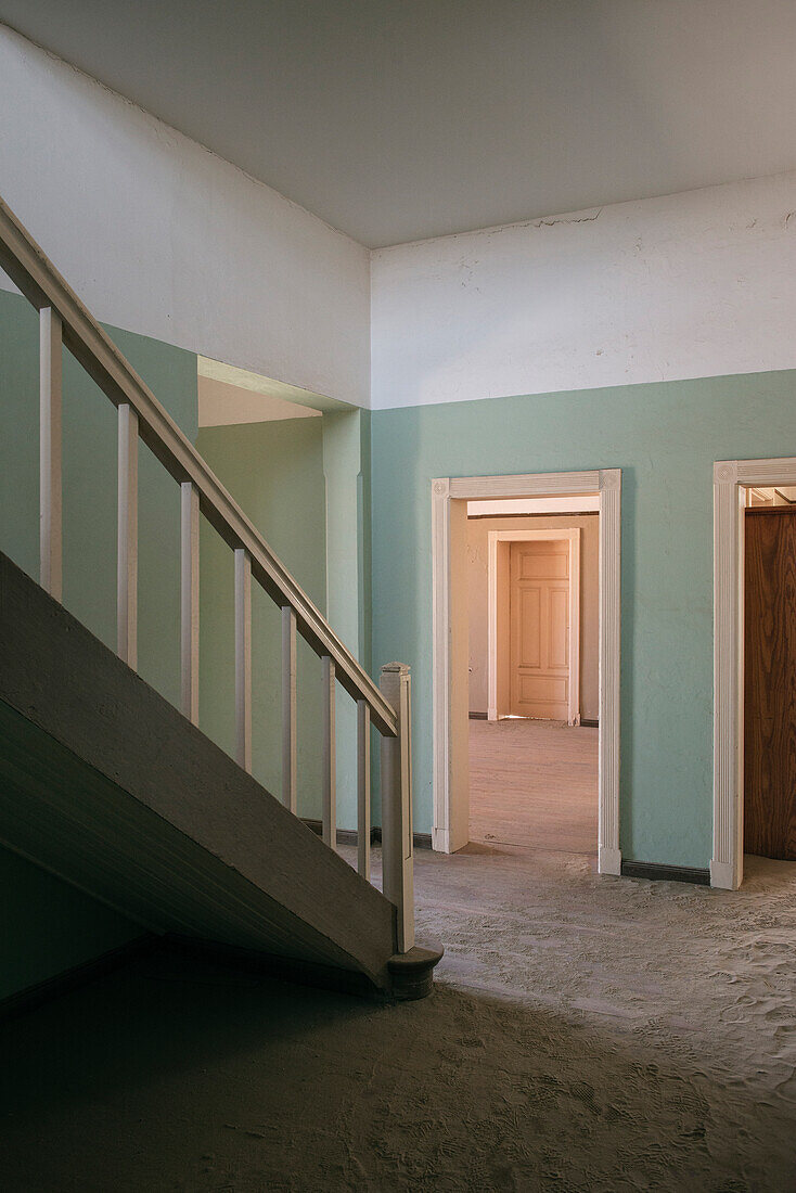 Stairway in a restaurated house, interior of the deserted ghost town in the Diamond restricted area, Kolmanskop near Luderitz, Namibia, Africa