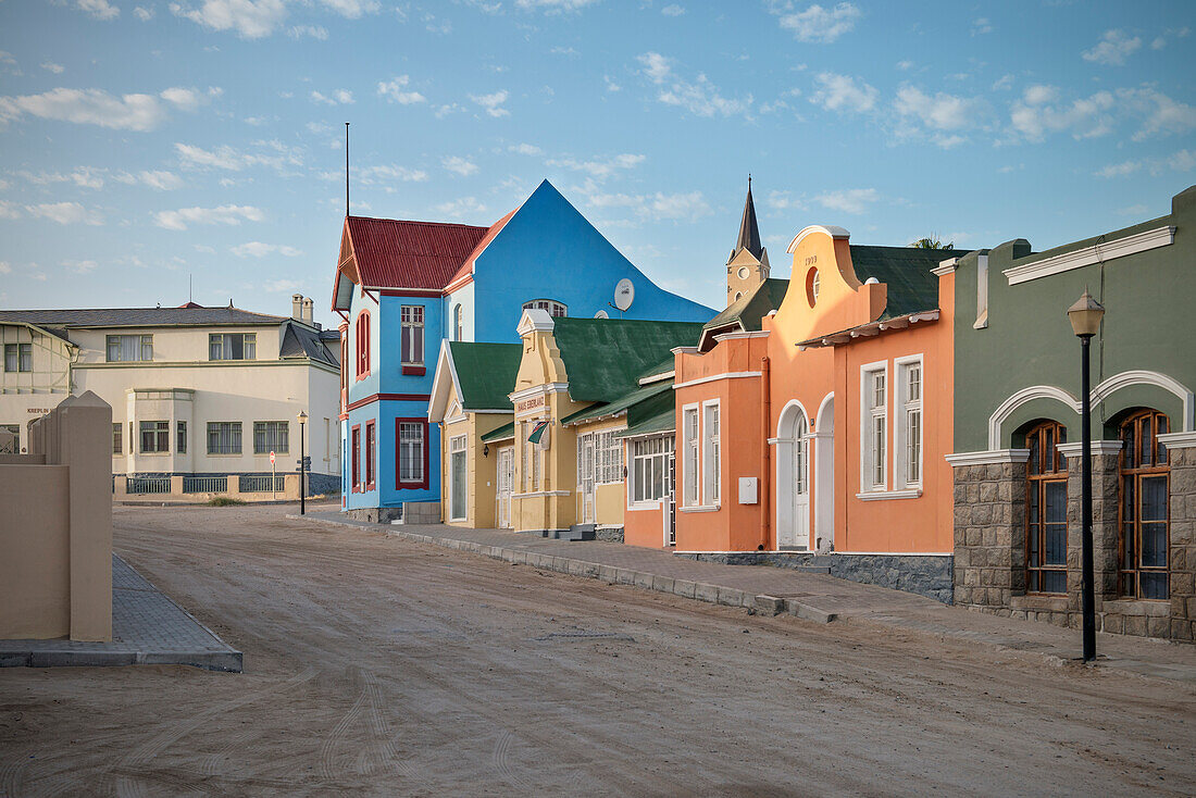 Typical German colonisation Art Nouveau architecture with rock church in the background, Luderitz, Namibia, Africa