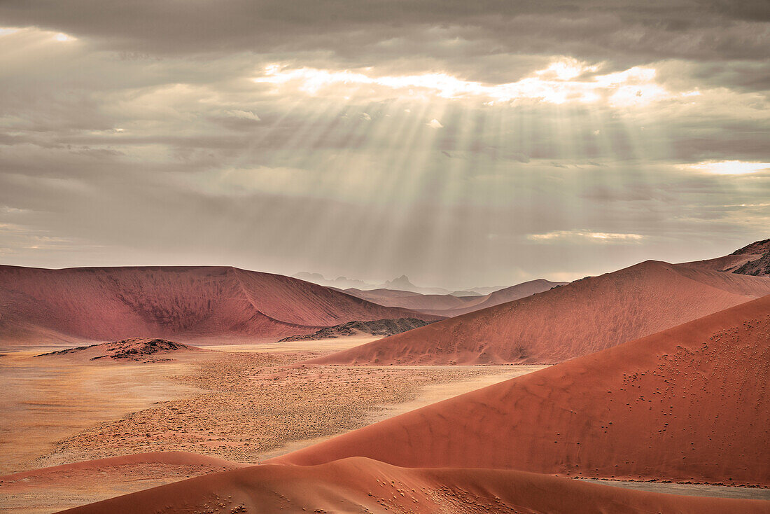 Panoramic view from Dune 45 to the landscape around Sossusvlei, sun rays breaking through the clouds, Namib Naukluft National Park, Namibia, Namib desert, Africa