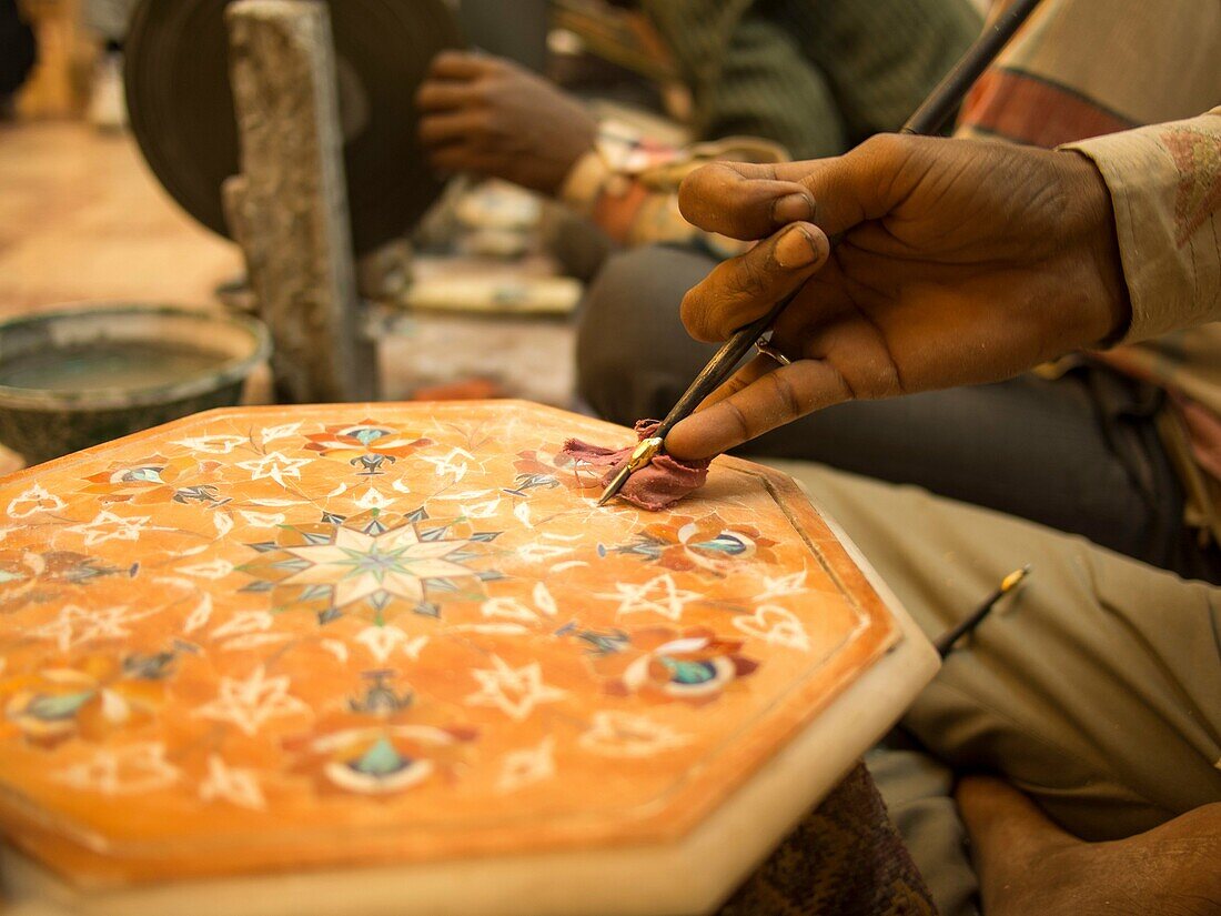 Man using hand tool to design a marble in Agra, Uttar Pradesh, India.