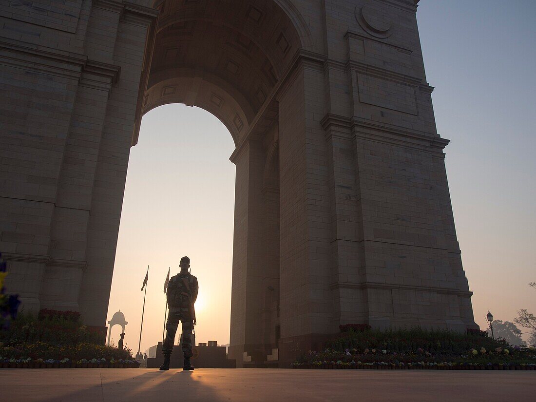 Security guard standing at India Gate in New Delhi, India.