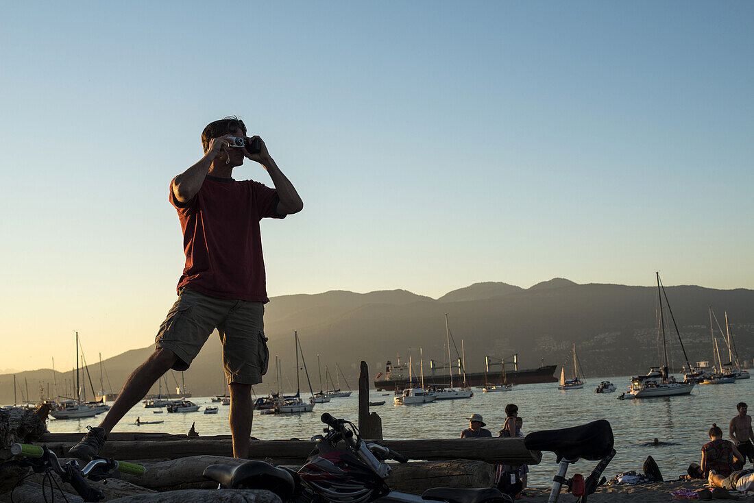 a man takes a photo at Jericho Beach, Vancouver, BC, Canada