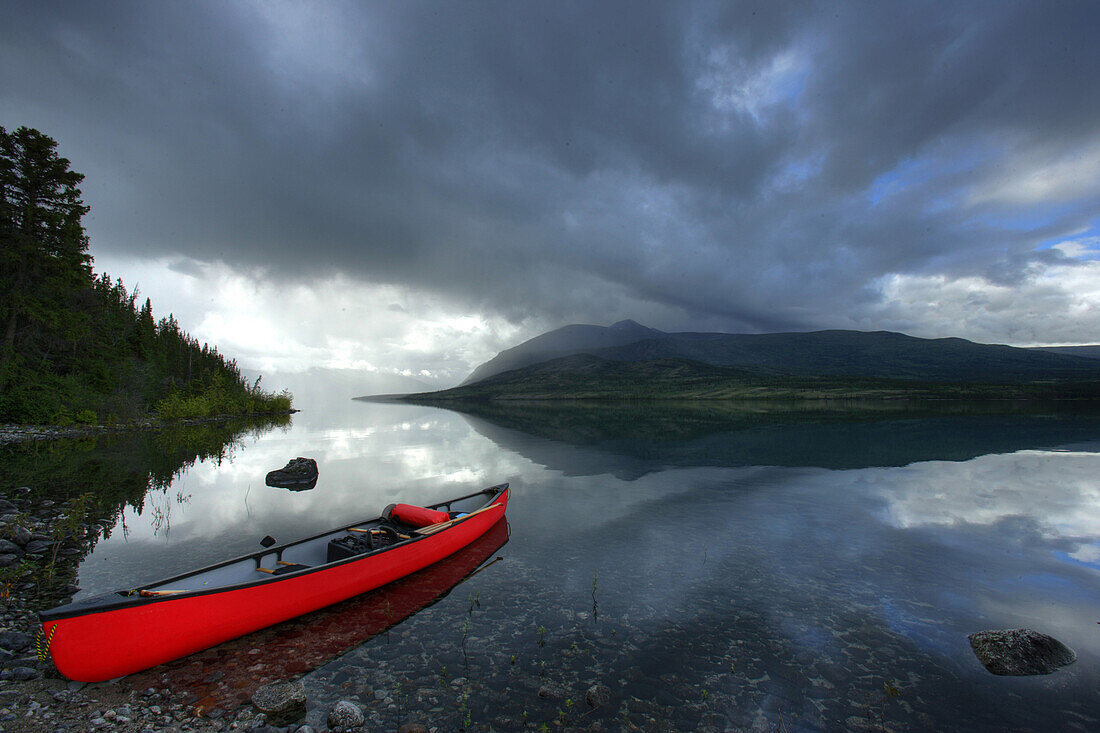 Canoe With Traveling Gear And Storm Clouds On Kusawa Lake, Yukon