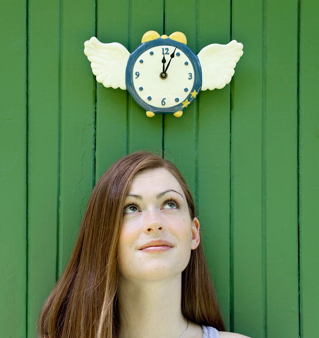 Young Woman Looking Up At Clock As Time Flies, Ontario