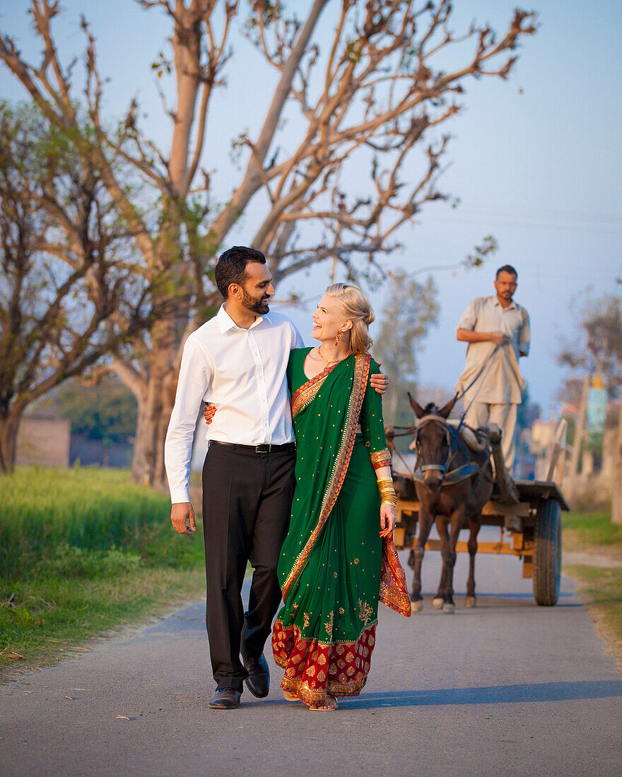 'A Mixed Race Couple Walking In An Embrace Down A Path; Ludhiana, Punjab, India'