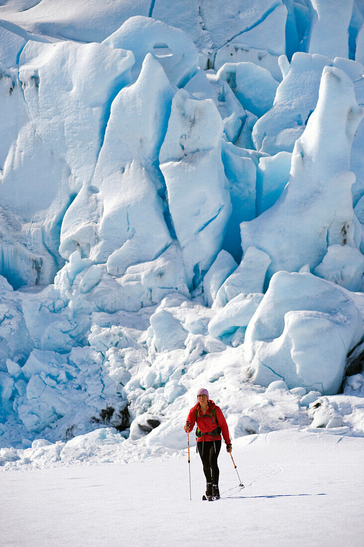 Female Skier Tours In Front Of Portage Glacier During A Spring Day Of Skiing On Portage Lake In Chugach National Forest, Alaska