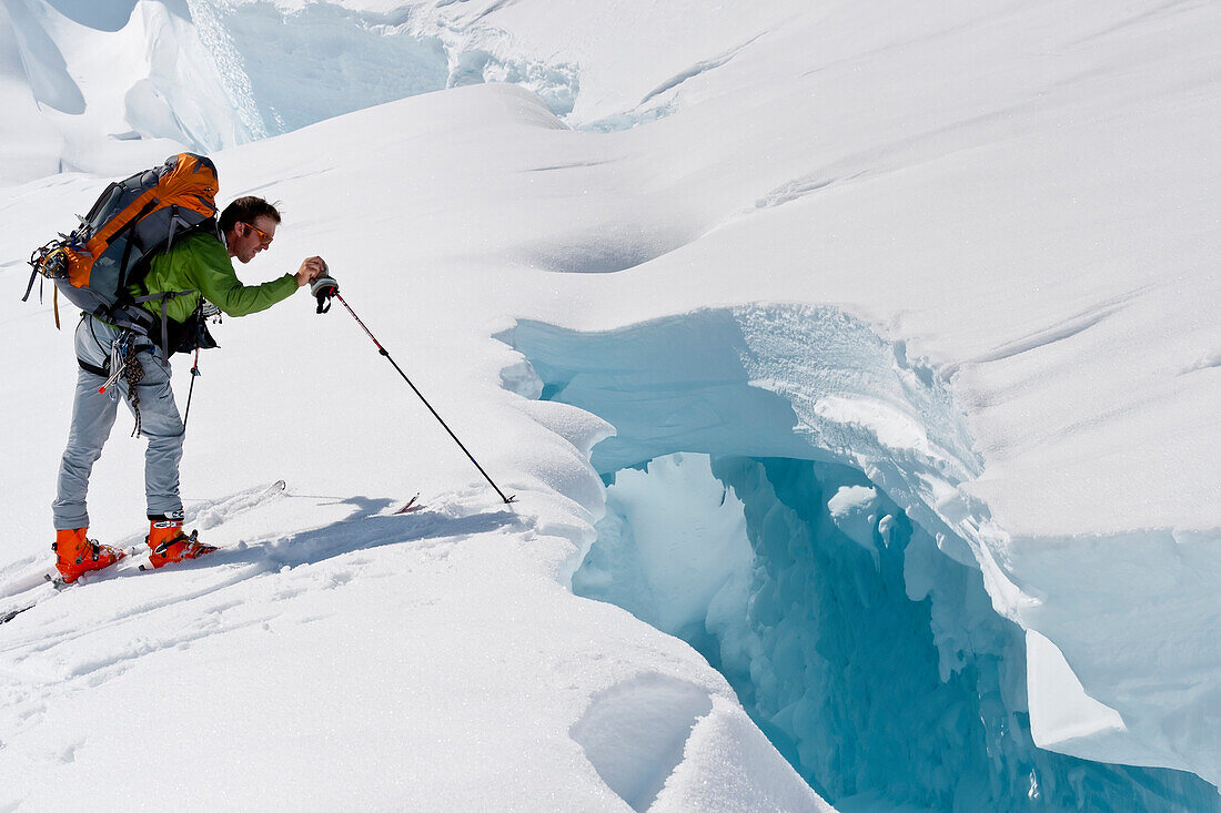 Skier Probing Edge Of A Dangerous Crevasse On The Upper Triumvirate Glacier, Tordrillo Mountains, Winter In Southcentral Alaska