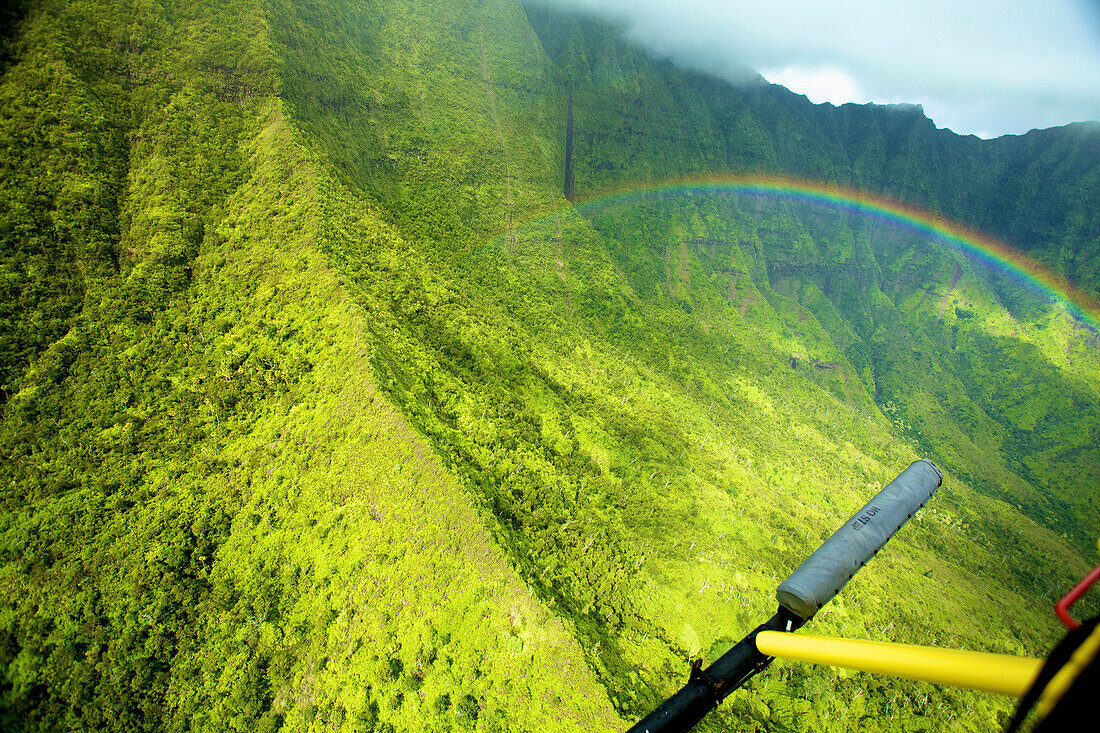 'A rainbow across a steep green mountain face; Hawaii, United States of America'