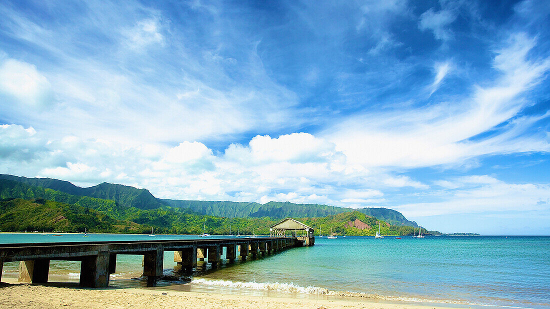 'A pier leading out from the beach to a covered structure; Hawaii, United States of America'