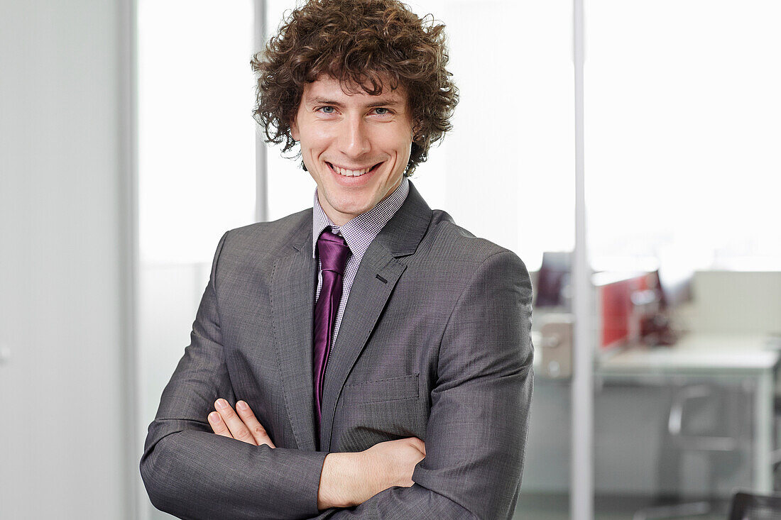 Portrait of businessman with curly hair wearing suit and tie