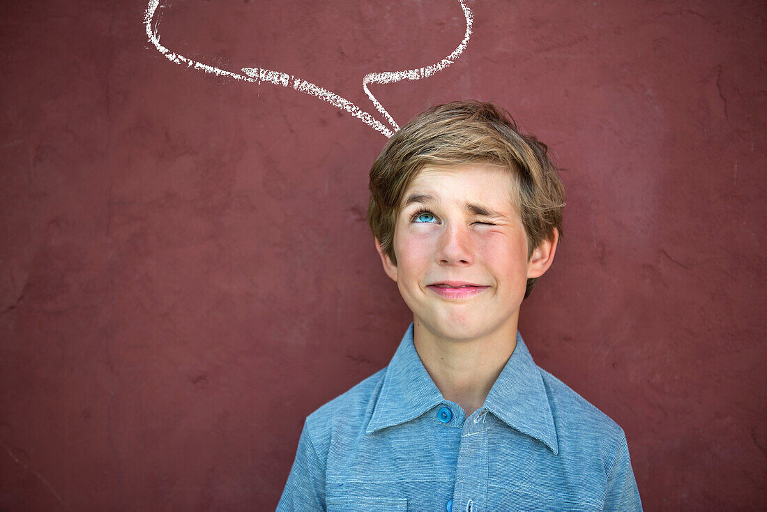 Boy looking up at speech bubble on red wall