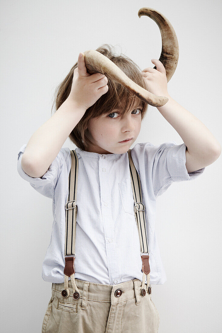 Boy posing with animal horn
