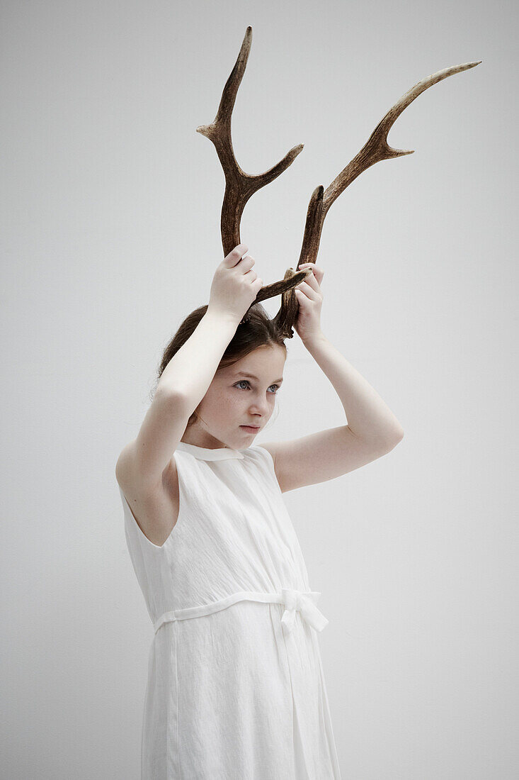 Girl posing with antlers on head
