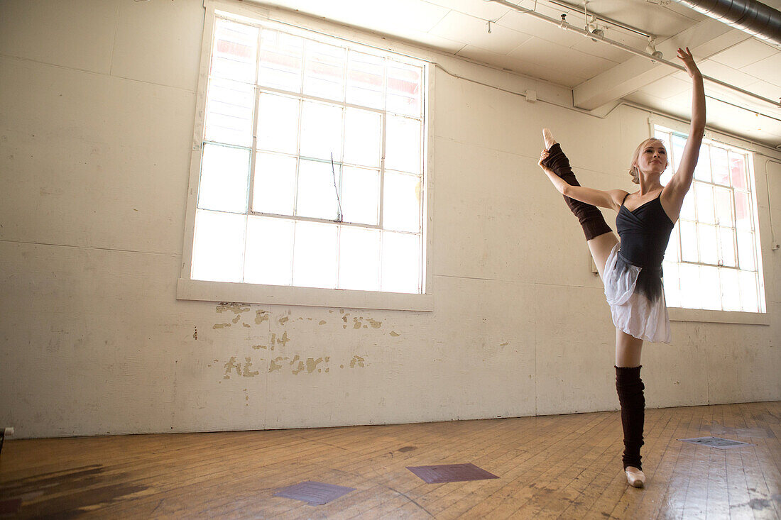 Ballet dancer on one leg in studio
