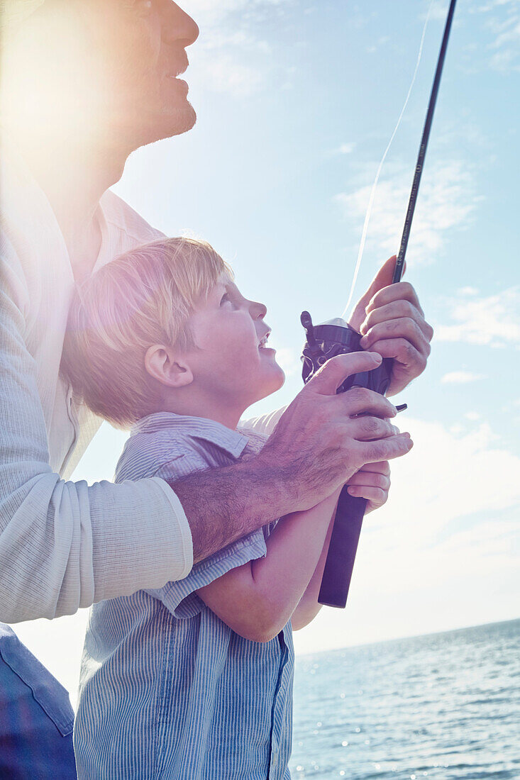 Grandfather and grandson holding fishing … – License image – 70475147 ...