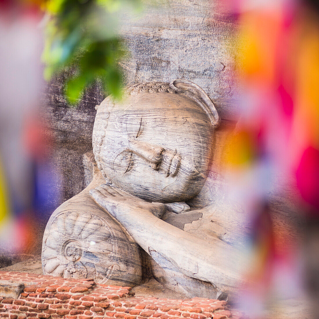 Buddhist prayer flags and reclining Buddha in Nirvana at Gal Vihara Rock Temple, Polonnaruwa, UNESCO World Heritage Site, Sri Lanka, Asia