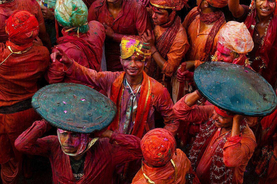 Guys in red colors playing during Lathmar Holi in the temple of Nandgaon in India