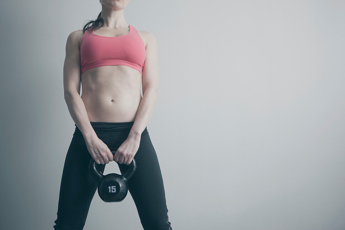 Caucasian woman holding kettle bell, Saint Louis, Missouri, USA