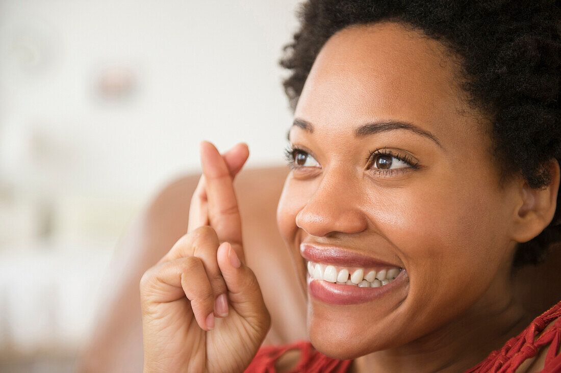 Close up of Black woman smiling with fingers crossed, Jersey City, New Jersey, USA
