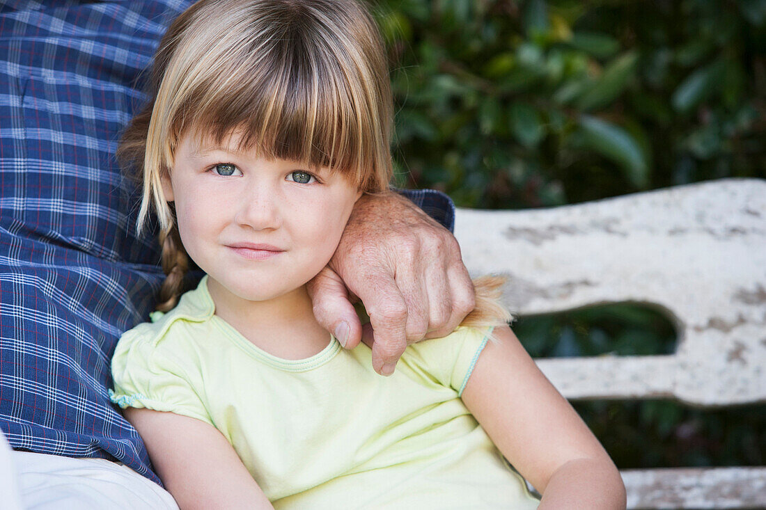 Caucasian girl sitting with grandfather on bench, Cape Town, Western Cape, South Africa